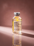 Ampolla KOEC Deep Collagen — detalle del frasco con hebras de seda doradas