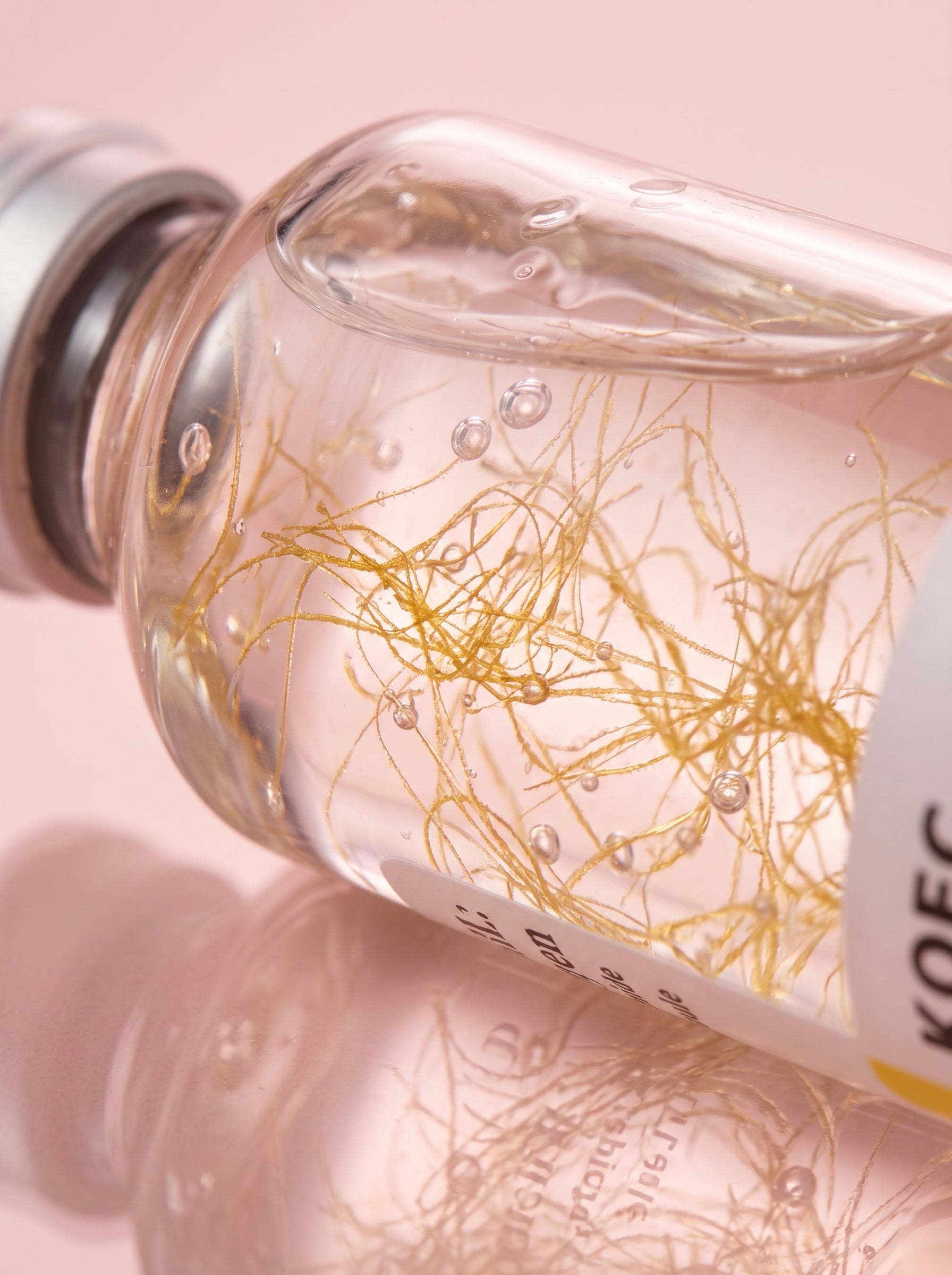 Macro de las hebras doradas de péptidos de seda en el sérum KOEC Deep Collagen
